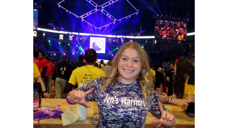 Penn State DuBois student Paige Miller stands on the dance floor of the Bryce Jordan Center during THON 2025 wearing a “Jen’s Warriors” tee shirt in remembrance of her mother, who passed away in 2019 after a battle with cancer.
