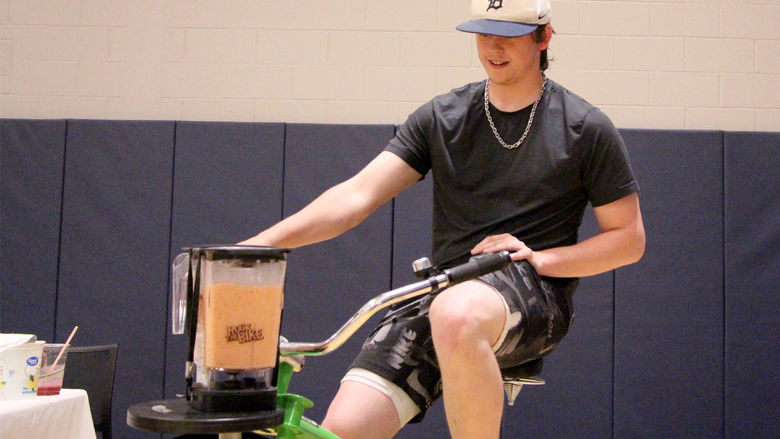Penn State DuBois second year student Josh Ross makes himself a smoothie by using the smoothie bike during the earth day celebration at Penn State DuBois.