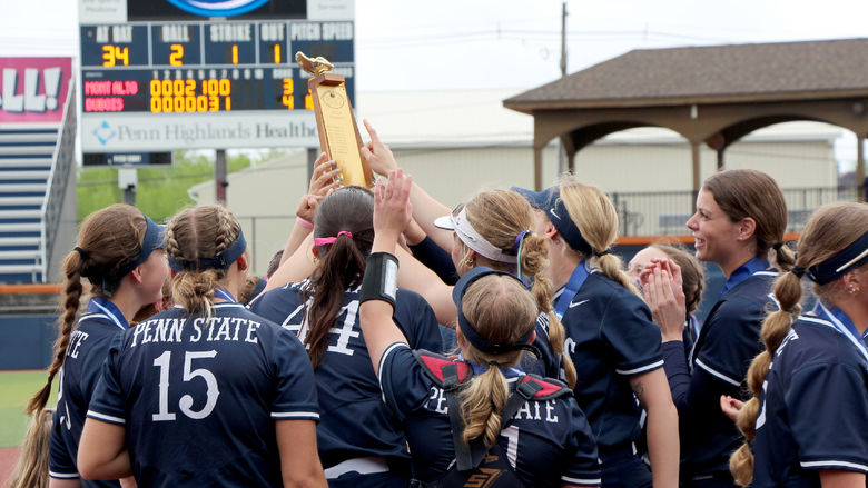 Members of the Penn State DuBois softball team gather and celebrate with the conference championship trophy after winning the championship at Heindl Field on May 4. This marked the first time in program history that the team secured the conference championship.