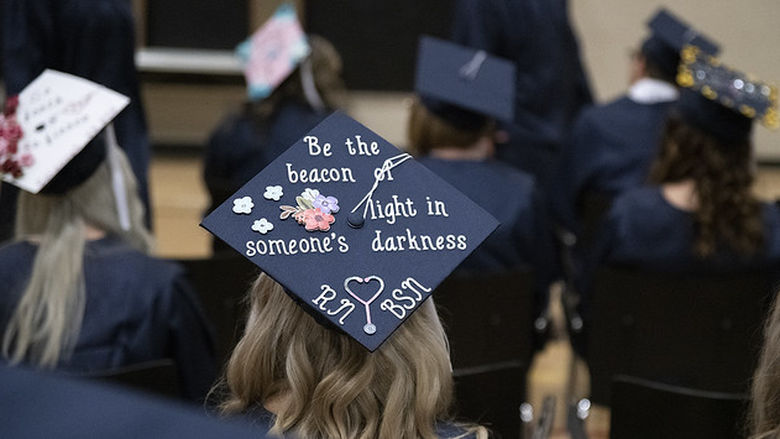 A 2019 Penn State Fayette graduate's cap reads "Be the beacon of light in someone's darkness."