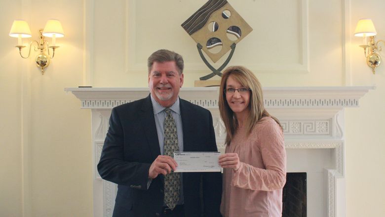 Chancellor M. Scott McBride accepts a check from Pam Walsh of CBT. 