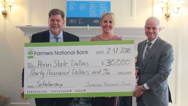 Chancellor M. Scott McBride accepts a check for the establishment of an Open Doors Scholarship from Farmers National Bank 
