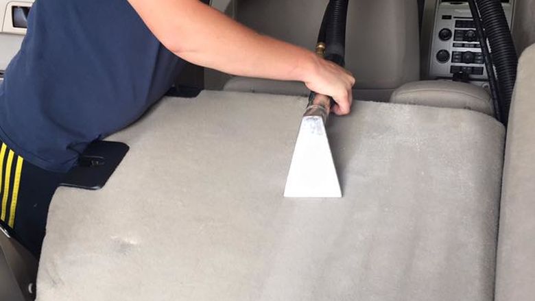 Kristy Hanes, works to detail the interior of a customer's car at her business. 
