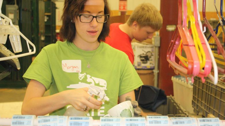 Freshman Morgan Young, of Clearfield, cleans and labels items for sale in Goodwill stores 