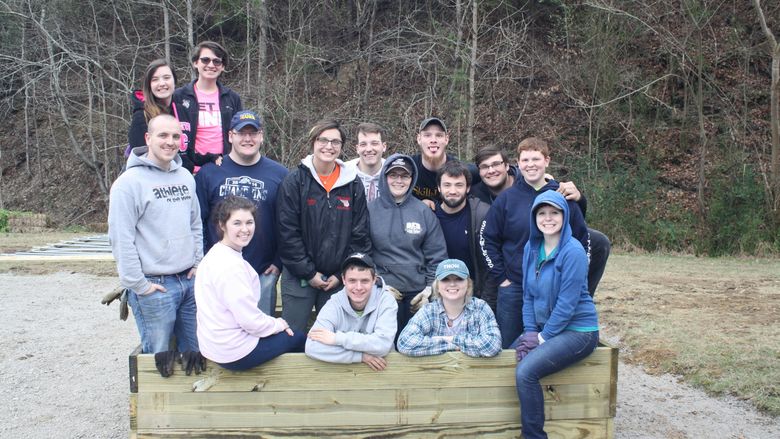 Students pause for a photo inside one of the community garden planting boxes they constructed. 
