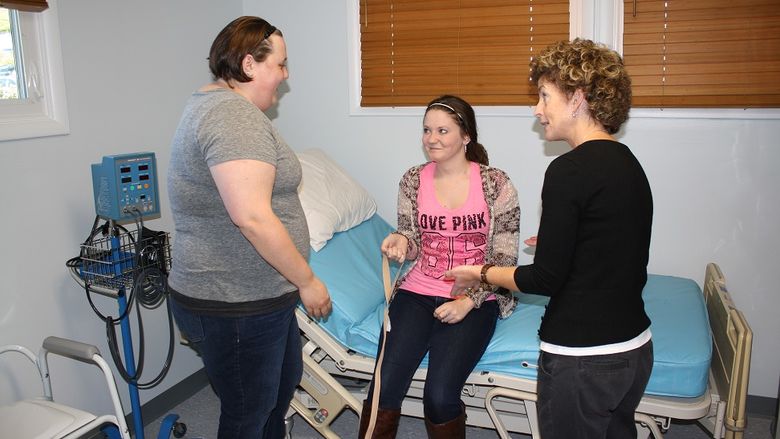 Students complete self-care training lab exercises in the OT House lab space.