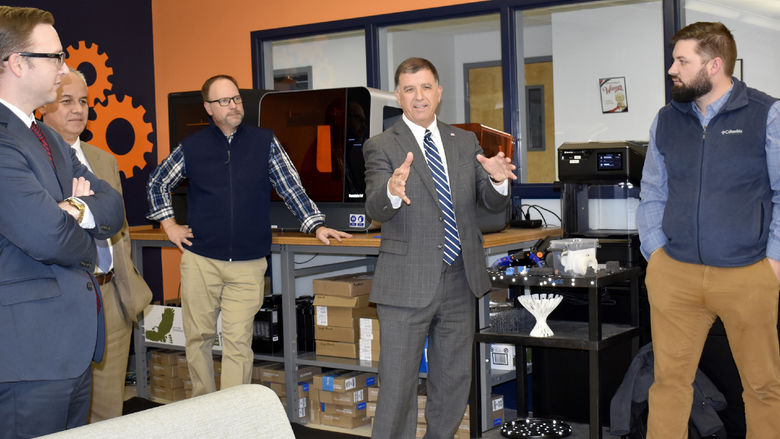 Brad Lashinsky, third from left, and John Williams, center, provide a demonstration of  3D scanning and printing equipment to the leadership at CNB Bank