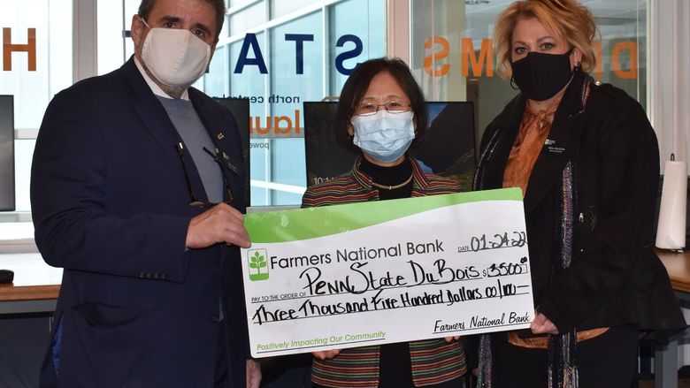 Farmers National Bank presents a $3,500 check to support offerings of youth programs on campus. 