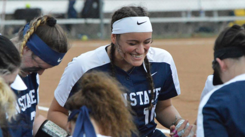 Members of Penn State Fayette's softball team huddle for good luck