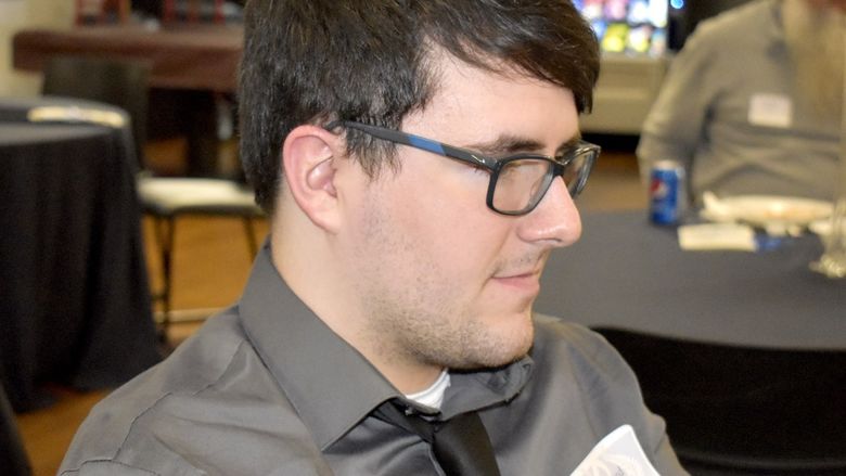 A person wearing glasses and a grey shirt