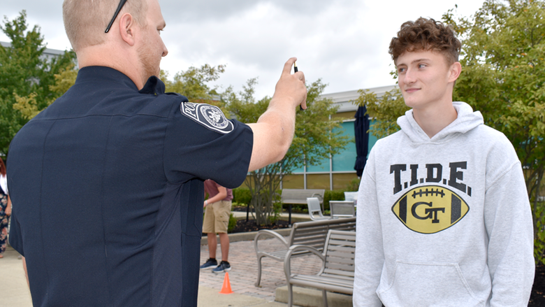 Officer Haag explains the eye test process called horizontal gaze nystagmus with student volunteer, Thad Butler.