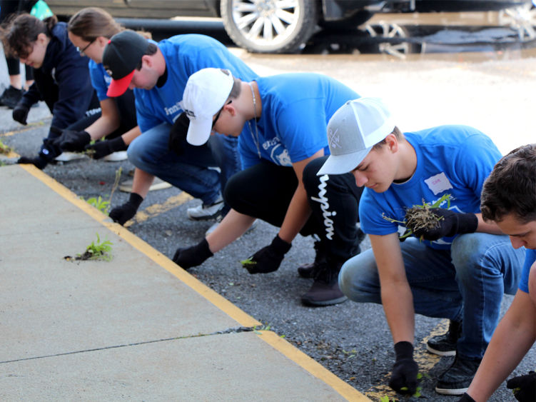 Incoming student at Penn State DuBois remove weeds from the grounds of the Tri County Church, as part of outreach day efforts during new student orientation.
