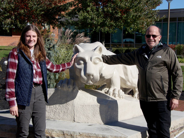 Two people stand on either side of the Lion Shrine