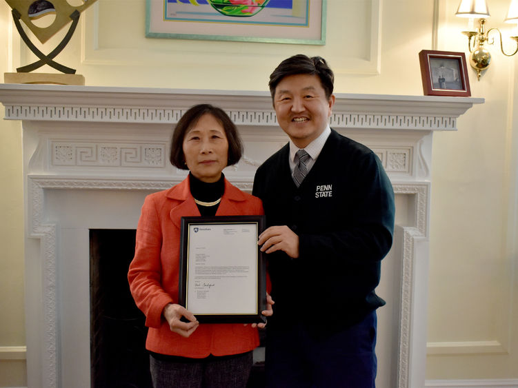 Penn State DuBois chancellor and chief academic officer Jungwoo Ryoo, right, presents Pingjuan Werner with a framed copy of the letter certifying her as a distinguished professor, the highest professorial distinction at the University