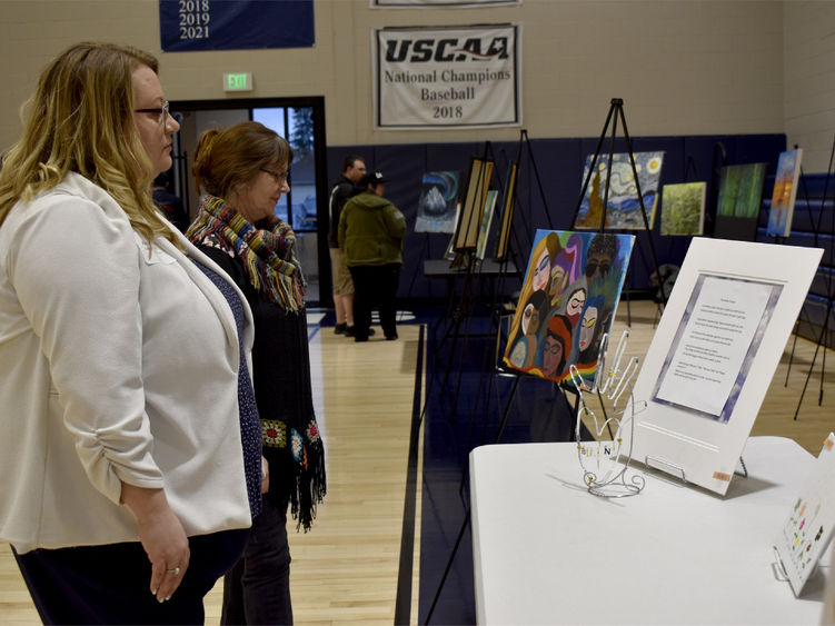 Attendees view some of the artwork submitted at the annual campus and community art show, hosted by the IDREAM Team at Penn State DuBois.