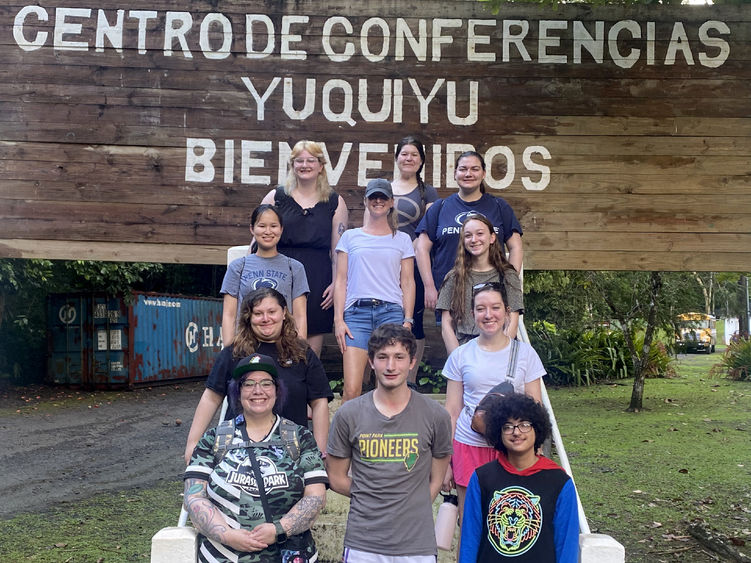 A group of people posing in front of sign reading, "CENTRO DE CONFERENCIAS YUQUIYU BIENVENIDOS."