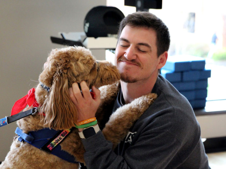 Penn State DuBois third-year student Jeff Romano enjoys the comfort a therapy dog gives him during one of the events of De-Stress Fest at Penn State DuBois.