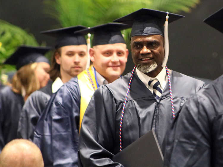 Graduates wearing caps and gowns smiling