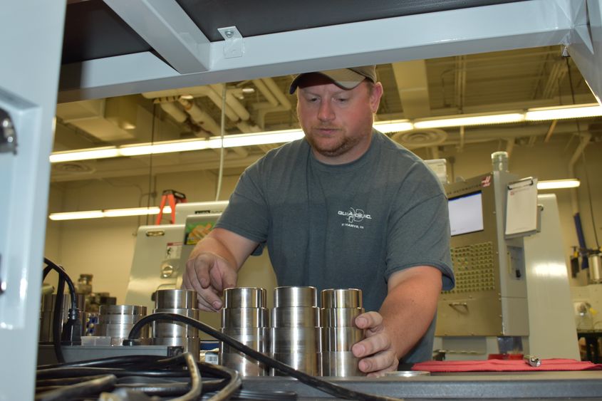 Instructor Curt Beck pulls newly created parts off of a CNC machine in the Penn State DuBois engineering labs.  