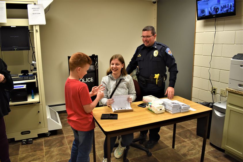 Student Hayley Knepper and Sandy Township Police Chief Kris Kruzelak fingerprint Brett Sullivan. 