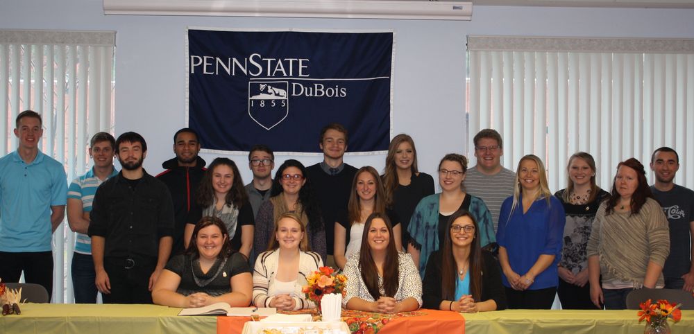 New members who participated in the induction ceremony are pictured with the Delta Mu Sigma board.