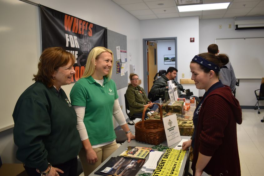 Vendors and students interact at the Assistive Technology Fair. 