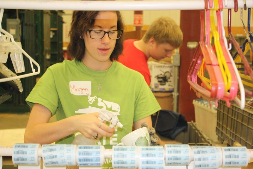 Freshman Morgan Young, of Clearfield, cleans and labels items for sale in Goodwill stores 