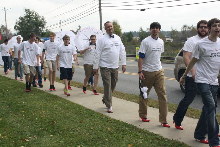 Men walk in high heels along route 255. 