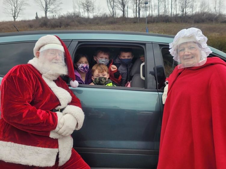 Santa and Mrs. Claus greeting childen on campus. 