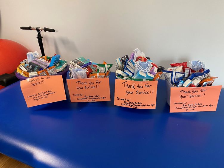 Gift baskets with self-care items that were assembled for first responders sit on a blue table.